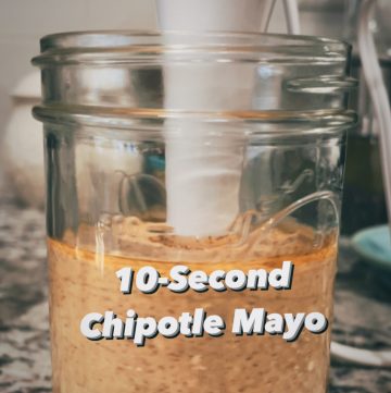 a ball jar filled with creamy orange chipotle mayo, with an immersion blender and the words "10-second chipotle mayo"