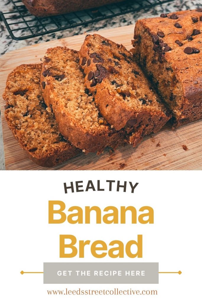 close up shot of sliced einkorn banana bread on a wooden cutting board with the word "Healthy Banana Bread Recipe" overlaid