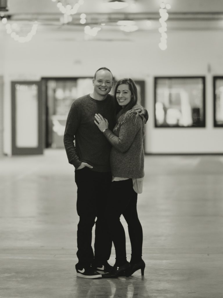 black and white photo of a man and woman smiling with their arms around each other